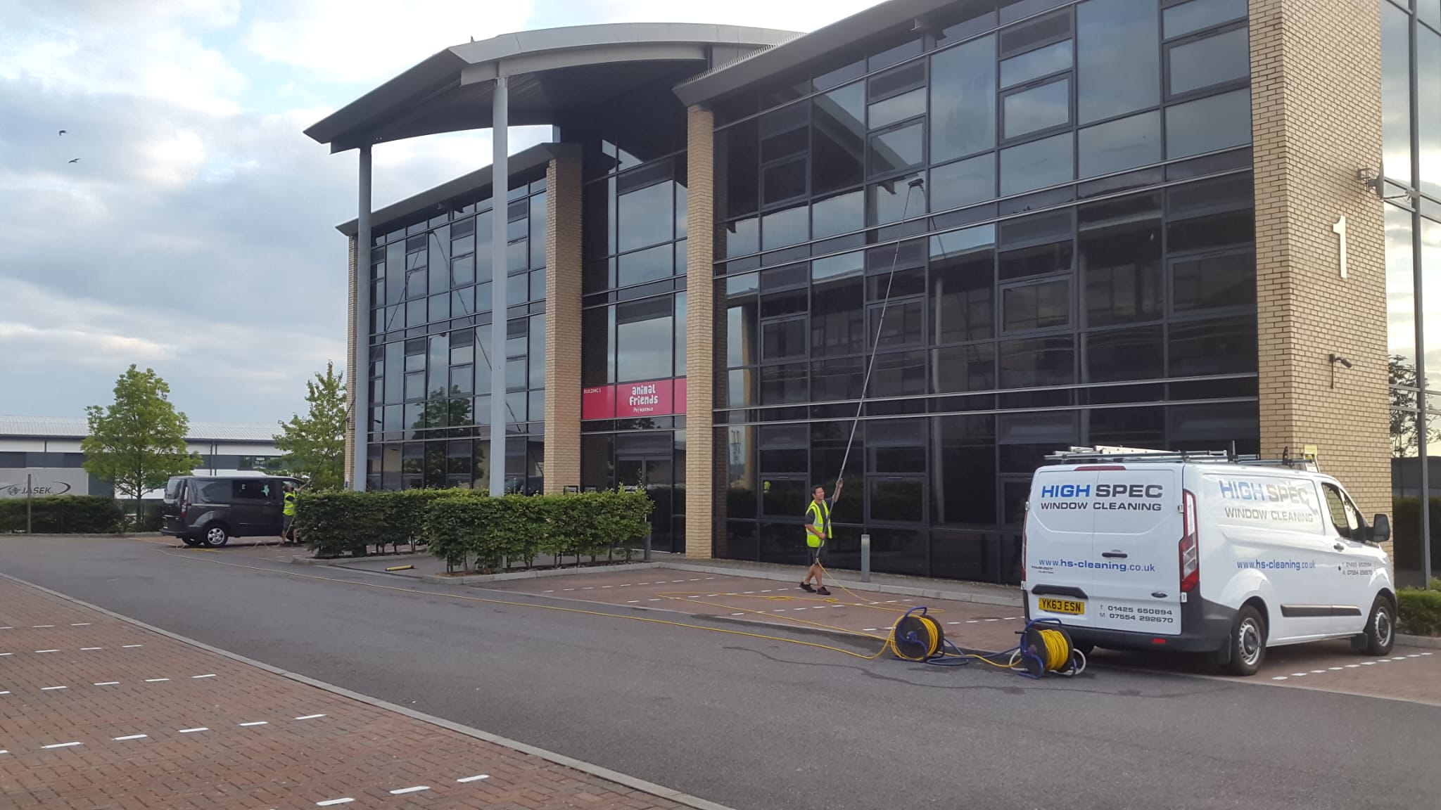HighSpec window cleaners cleaning a commercial building with tall windows
