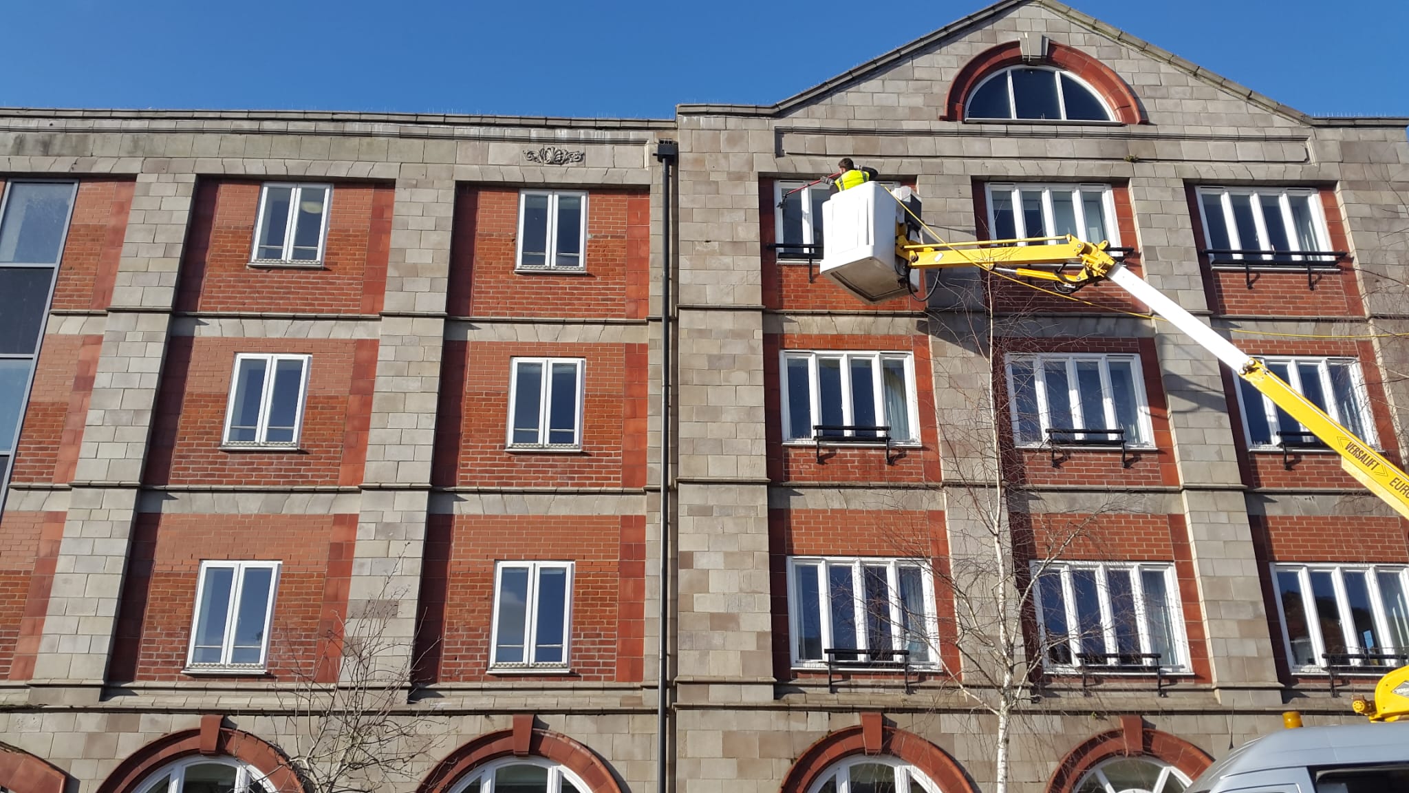 College building being washed by HighSpec window cleaners using a crane